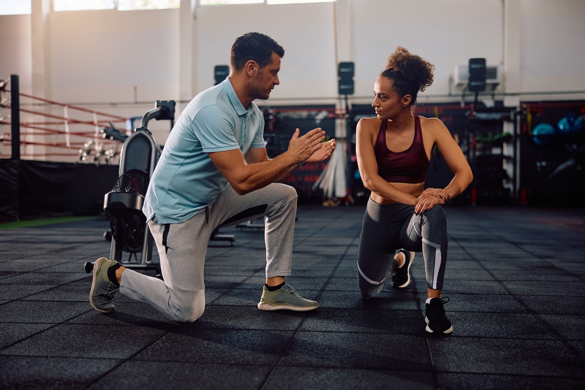 Athletic woman having sports training with personal trainer in a gym.